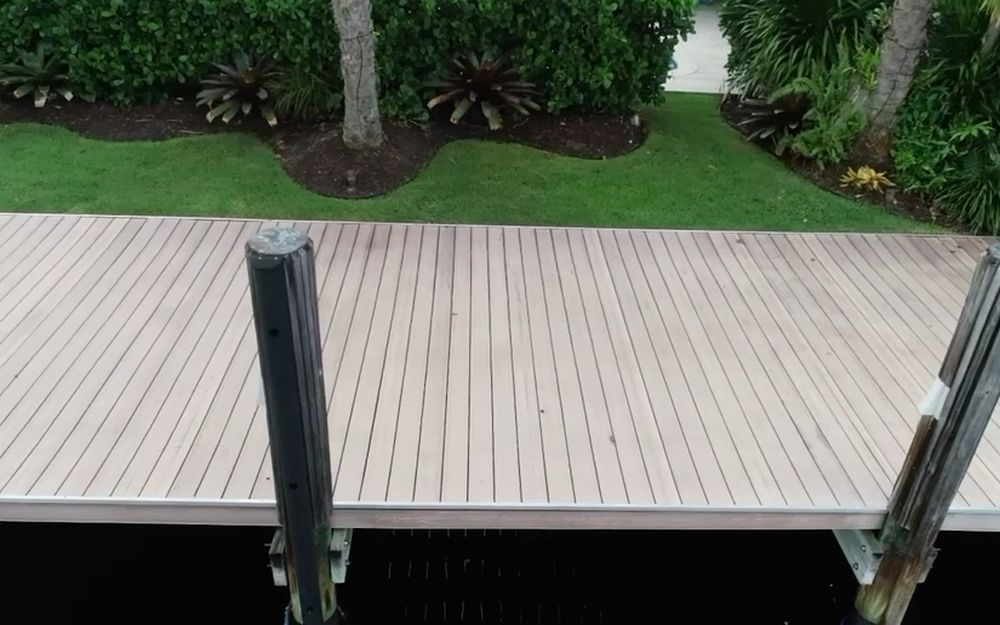 A dock deck with a piling and boat lift hardware on a South Florida waterway