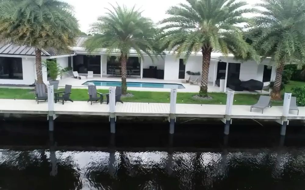 A waterfront home behind a concrete seawall and cap on a South Florida canal